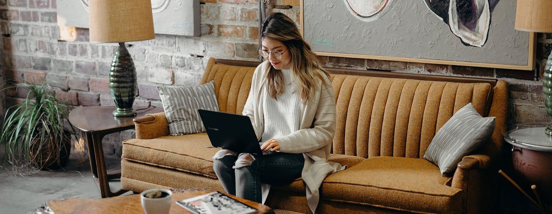 Gorgeous natural light in your living space a woman sitting on a couch working on a laptop
